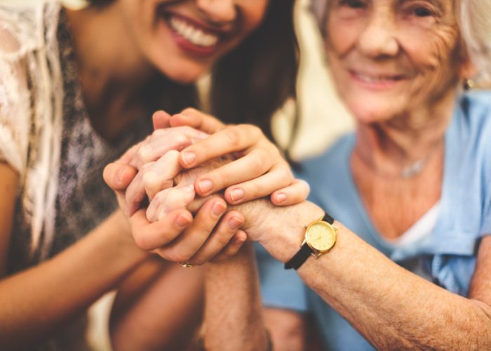 Closeup-of-a-smiling-nurse-holding-a-senior-womans-hand-000046121660_Small